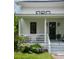 Inviting front porch with white railing, dark blue door, and well-manicured landscaping at 2 Live Oak Ave, Charleston, SC 29407