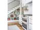 White kitchen featuring double oven, subway tile backsplash, and under stair shelving at 2 Live Oak Ave, Charleston, SC 29407