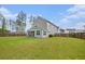 Expansive backyard with lush green lawn and a privacy fence, surrounded by tall trees and blue skies at 200 Clearblue Loop, Summerville, SC 29486
