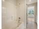 Bright bathroom featuring a shower-tub combo and tiled floors, showcasing a clean and functional design at 2037 Shell Ring Cir, Mount Pleasant, SC 29466