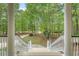 View from the front porch showcasing the driveway, lush landscaping, and mature trees at 2037 Shell Ring Cir, Mount Pleasant, SC 29466