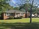 Inviting brick home with green lawn, mature trees, front porch, and traditional windows, creating a cozy curb appeal at 210 Ellen St, Goose Creek, SC 29445