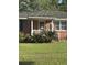Attractive brick home featuring a manicured lawn, a cozy porch, and decorative plantings, creating a welcoming entrance at 210 Ellen St, Goose Creek, SC 29445