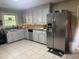 Well-equipped kitchen with stainless steel refrigerator, tile flooring, and ample cabinet space at 210 Ellen St, Goose Creek, SC 29445