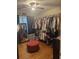 Spacious walk-in closet features ample clothing racks and a red ottoman at 210 Ellen St, Goose Creek, SC 29445