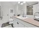 Well-lit bathroom featuring white cabinets, marble countertop, large mirror, and tiled shower with glass door at 2104 Royal Pine Dr, Seabrook Island, SC 29455