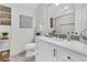 Well-lit bathroom featuring white cabinets, marble countertop, large mirror, and tiled shower with built-in shelves at 2104 Royal Pine Dr, Seabrook Island, SC 29455