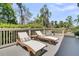 Outdoor deck with two chaise lounges, small table, and a view of the surrounding trees at 2104 Royal Pine Dr, Seabrook Island, SC 29455
