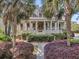 Beautiful Southern-style home with a welcoming porch, manicured landscaping, and mature palm trees framing the entryway at 2104 Royal Pine Dr, Seabrook Island, SC 29455