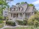 Elegant home featuring a charming porch and dormer windows, surrounded by lush greenery at 2104 Royal Pine Dr, Seabrook Island, SC 29455