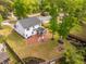 Aerial view showcases a home's backyard with a fire pit, screened porch, and lush landscaping at 217 7Th Ave, Mount Pleasant, SC 29464