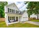 Inviting two-story house with white siding, black shutters, a front porch, and an attached two-car garage at 217 7Th Ave, Mount Pleasant, SC 29464