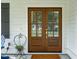 Elegant wooden double front doors with glass panels, complemented by black shutters and a charming welcome mat at 217 7Th Ave, Mount Pleasant, SC 29464