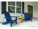 Cozy front porch featuring comfortable blue Adirondack chairs and a small decorative stone table at 217 7Th Ave, Mount Pleasant, SC 29464