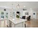 Open concept: kitchen island with seating, living room with fireplace and flatscreen TV, and double french doors to back yard at 217 7Th Ave, Mount Pleasant, SC 29464