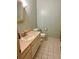 Simple bathroom with tile flooring, sink, vanity, toilet, and framed mirror at 240 Kerrison St, Varnville, SC 29944