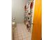 Standard bathroom featuring a toilet, tiled flooring, and a vibrant floral shower curtain at 240 Kerrison St, Varnville, SC 29944