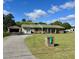 Charming single-story brick home featuring a lush lawn, and a detached two car garage, set against a backdrop of mature trees at 240 Kerrison St, Varnville, SC 29944