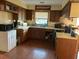 Compact kitchen with wooden cabinets, countertops, window view, and wood flooring at 240 Kerrison St, Varnville, SC 29944