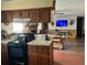 Cozy kitchen with dark cabinets, breakfast bar, and open to a living area at 240 Kerrison St, Varnville, SC 29944