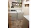 Functional laundry room with washer, dryer, storage shelves, and vinyl flooring at 240 Kerrison St, Varnville, SC 29944