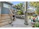 Backyard featuring a large deck with a dining table, seating, and mature landscaping at 2530 Jasper Blvd, Sullivans Island, SC 29482