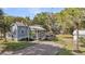 Charming blue cottage-style home with a gravel driveway, fenced yard, and mature landscaping at 2530 Jasper Blvd, Sullivans Island, SC 29482