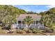 Charming single-story home featuring a full front porch, palm trees, and a well-manicured lawn at 2530 Jasper Blvd, Sullivans Island, SC 29482
