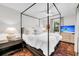 Bright main bedroom featuring a canopy bed, bedside tables, and a flatscreen television at 2530 Jasper Blvd, Sullivans Island, SC 29482