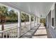 Inviting covered front porch with seating and wooden flooring overlooking the street at 2530 Jasper Blvd, Sullivans Island, SC 29482