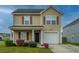 Charming two-story home with vinyl siding, well-maintained landscaping, and an attached garage at 3033 Kinswood Ln, Ladson, SC 29456