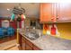 Galley kitchen area featuring stainless steel sink, cherry wood cabinets, and pot rack at 3033 Kinswood Ln, Ladson, SC 29456