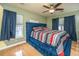 Main bedroom features a tufted bed frame, ceiling fan, and hardwood floors at 3033 Kinswood Ln, Ladson, SC 29456