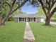 Inviting home with a well-manicured lawn, framed by mature trees, and charming curb appeal at 330 Crestwood Dr, Moncks Corner, SC 29461
