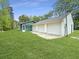 Exterior shot of a three car garage, connected to a charming green house with lush greenery at 330 Crestwood Dr, Moncks Corner, SC 29461