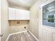 Functional laundry room featuring overhead storage cabinets, new floors, and a back door at 330 Crestwood Dr, Moncks Corner, SC 29461