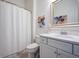 Clean bathroom with a white vanity, matching faucet, a framed mirror, and a shower with a white curtain at 332 Fish Creek Ct, Summerville, SC 29486