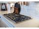 Modern gas cooktop on a white countertop with a white subway tile backsplash at 332 Fish Creek Ct, Summerville, SC 29486