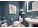 Stylish powder room with pedestal sink, unique wall art, and modern decor at 332 Fish Creek Ct, Summerville, SC 29486