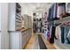 Spacious walk-in closet with custom shelving, center bench, and wood floors at 332 Fish Creek Ct, Summerville, SC 29486
