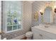 Charming bathroom featuring patterned wallpaper, a stylish mirror, and a window providing natural light at 3424 Henrietta Hartford Rd, Mount Pleasant, SC 29466