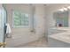 Bright bathroom with a soaking tub under a window, double vanity, and neutral tile floors at 3424 Henrietta Hartford Rd, Mount Pleasant, SC 29466