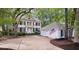 Beautiful two-story home with white siding, black shutters, and a large front yard with mature trees and a detached two-car garage at 3424 Henrietta Hartford Rd, Mount Pleasant, SC 29466