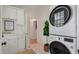 Convenient laundry room with stacked washer and dryer, storage cabinets, and a utility sink at 3424 Henrietta Hartford Rd, Mount Pleasant, SC 29466
