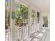 White porch with screen door, lush greenery and shade trees in view at 3424 Henrietta Hartford Rd, Mount Pleasant, SC 29466