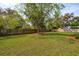 Large green backyard with wood fence, trees and partial view of neighborhood at 3683 Nassas St, Mount Pleasant, SC 29466