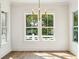 Well-lit dining area featuring hardwood floors, white trim, large windows, and a modern chandelier at 3683 Nassas St, Mount Pleasant, SC 29466