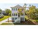 Charming white home with a raised foundation, complemented by a well-manicured lawn and mature trees at 3683 Nassas St, Mount Pleasant, SC 29466