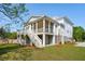 Charming two-story white home with screened porch, white stairs and green lawn at 3683 Nassas St, Mount Pleasant, SC 29466