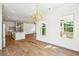 Bright, open-concept living area with wood floors, view of kitchen and stylish gold chandelier at 3683 Nassas St, Mount Pleasant, SC 29466